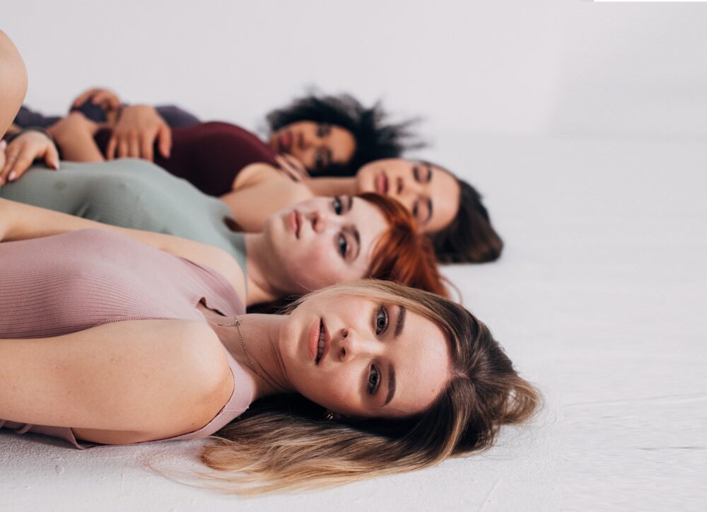 Cuatro mujeres jóvenes tumbadas en el suelo
