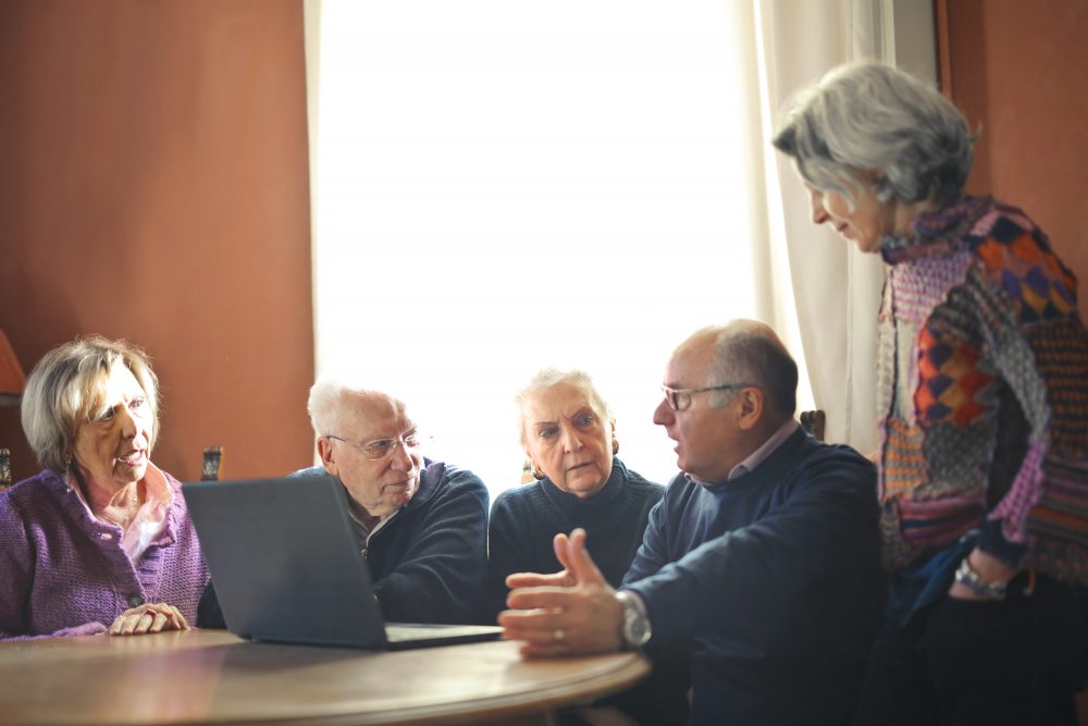 Grupo de personas mayores entorno a una mesa