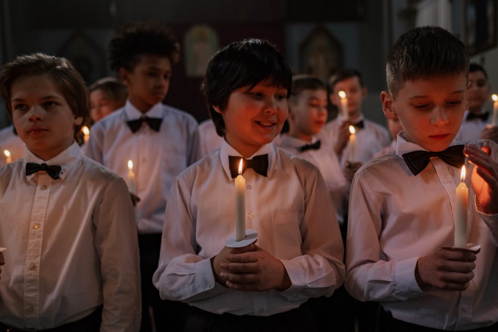 Niños de un coro con velas encendidas