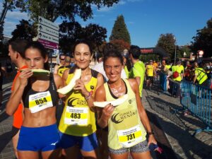 tres mujeres jóvenes con una rodaja de melón al terminar la carrera de la melonera