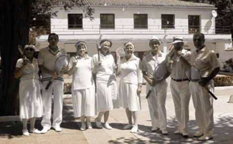 Grupo de gente en club de tenis con la indumentaria propia