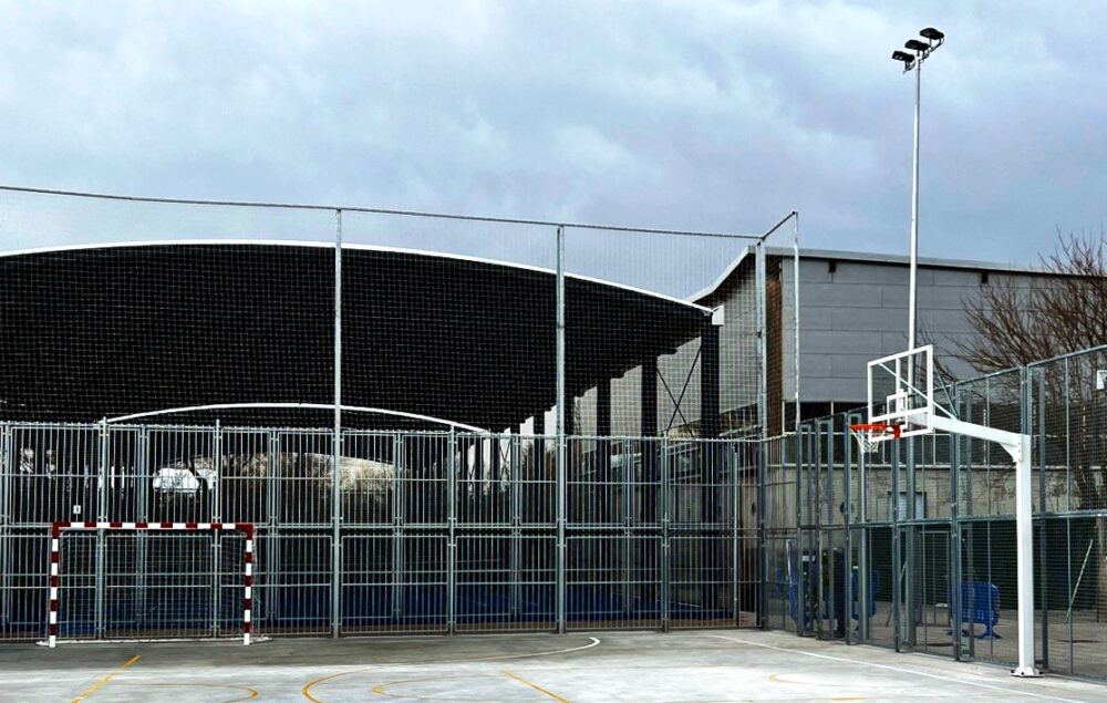 Instalaciones deportivas municipales de Barajas con pista exterior de baloncesto y pabellón cubierto, opción para practicar deporte y entrenamiento en gimnasio abierto durante agosto en Barajas.