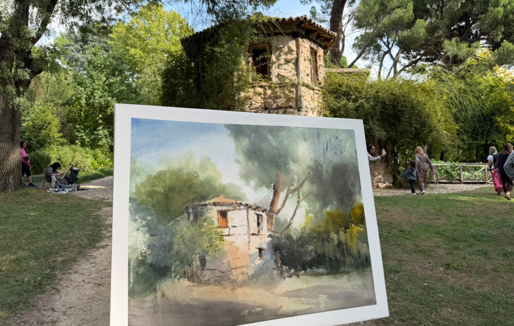 Certamen Pintura El Capricho Barajas en Madrid, obra realizada al aire libre frente a un edificio histórico del parque de El Capricho, durante una jornada del concurso de pintura rápida con participantes y visitantes entre jardines y arbolado.