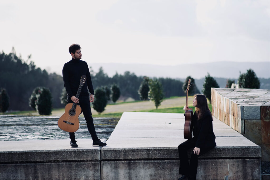 Un hombre y una mujer con guitarras del grupo Eresma Guitar Dúo en un paisaje de naturaleza