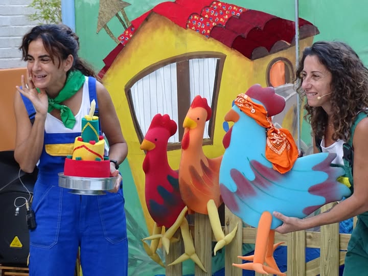 Fotografía de las payasas de la compañía Maiclown, en una granja con gallinas dibujadas