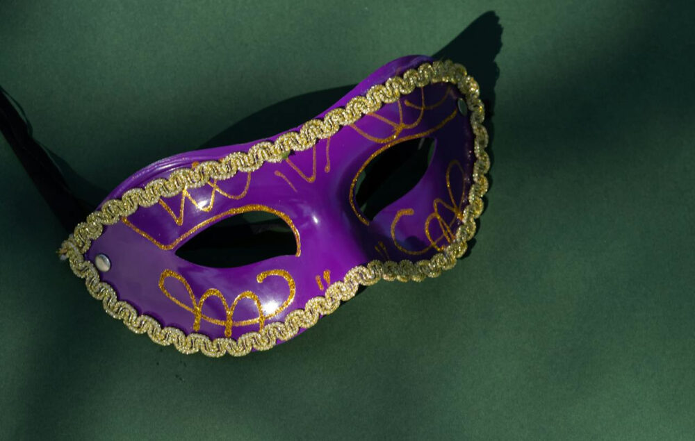 máscara de carnaval morada sobre un fondo verde