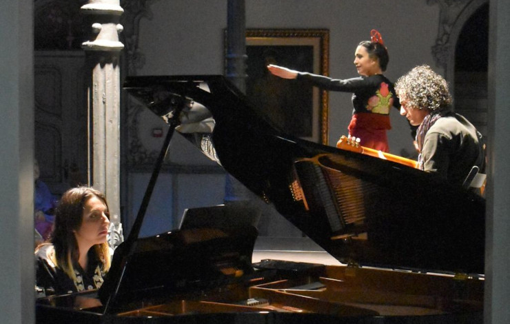 una actuación de una bailarina con dos músicos al lado