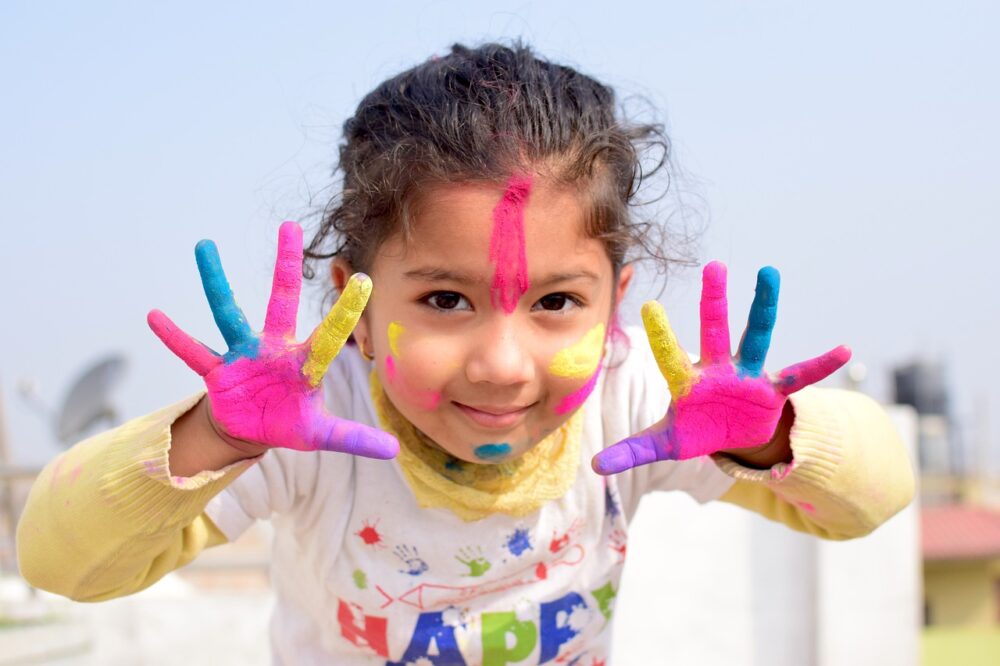 Niña con las manos pintadas de colores