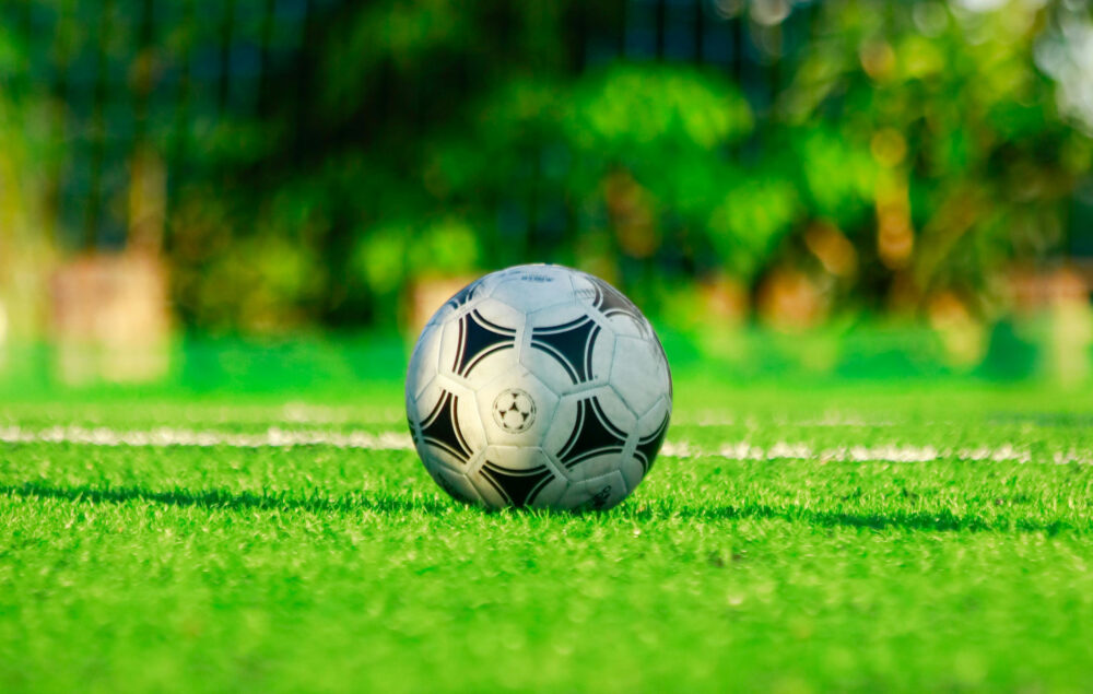 Un balón de fútbol sobre el césped de un campo de fútbol