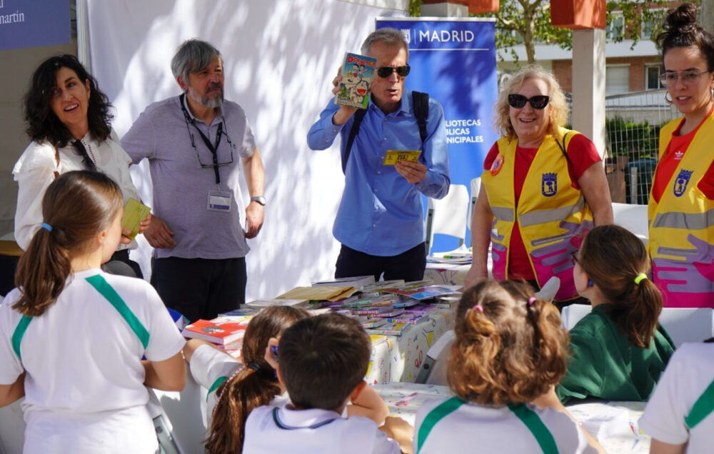 Voluntarios de madrid con chalecos en uno de los juegos con libros con los niños