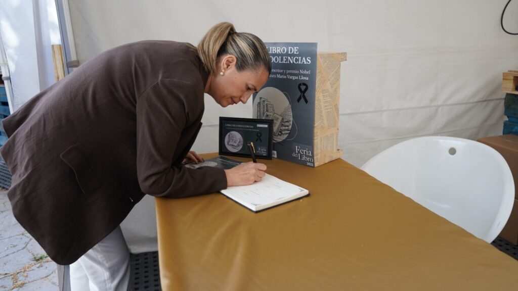 Yolanda Estrada firmando el libro de condolencias a Vargas llosa