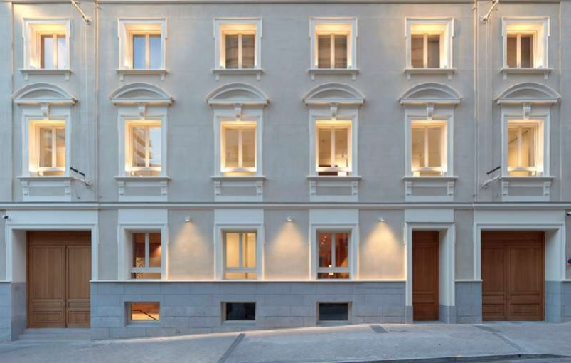 Detalles del adjunto Fachada-de-la-Fundacion-Maria-Cristina-Masaveu-Peterson de color blanco con las ventanas iluminadas
