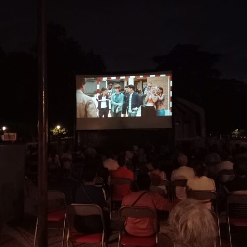 Imagen del cine de verano de Chamartín con el público de espaldas y una película en la pantalla