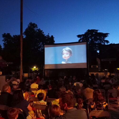 Imagen del cine de verano de Chamartín con el público de espaldas y una película en la pantalla