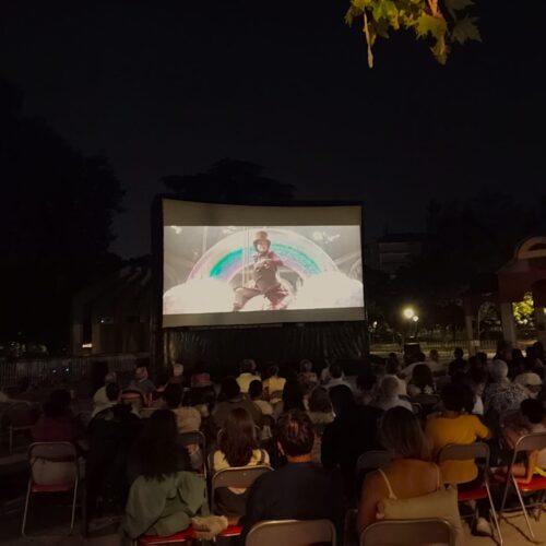Imagen del cine de verano de Chamartín con el público de espaldas y una película en la pantalla