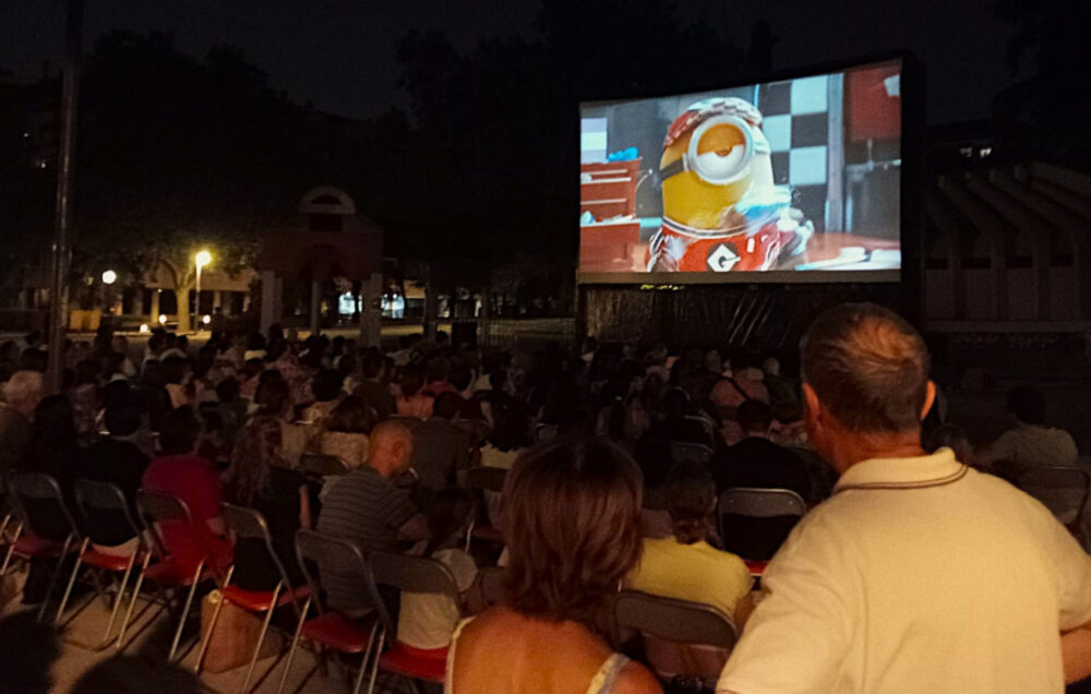 Imagen del cine de verano de Chamartín con el público de espaldas y una película en la pantalla