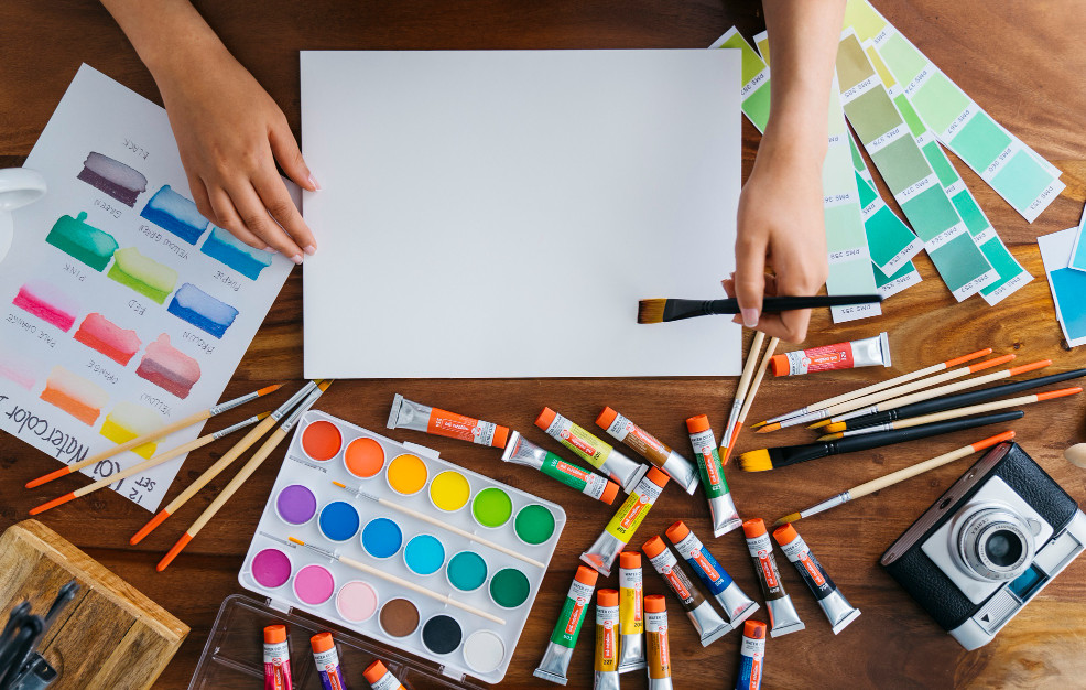 Unas manos ante un lienzo con pinturas