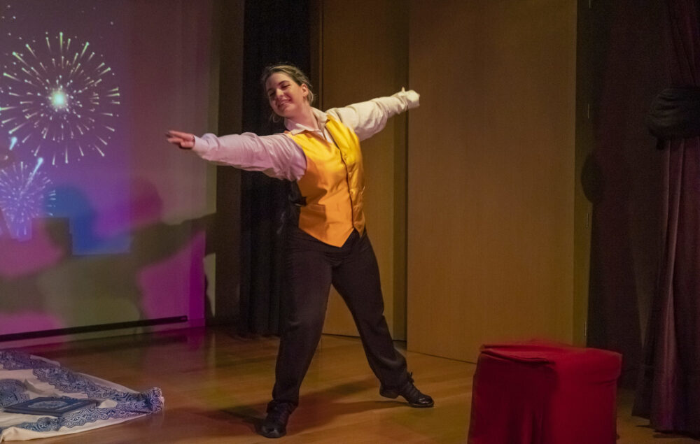 Una mujer bailando sobre un escenario vestida con traje