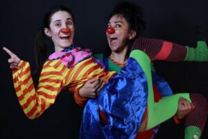 Dos payasos sujetándose en brazos