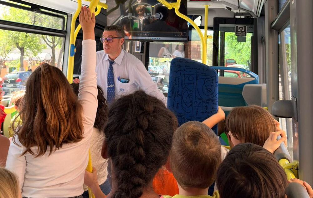 Un conductor de emt madrid explica a unos alumnos dentro del autobús