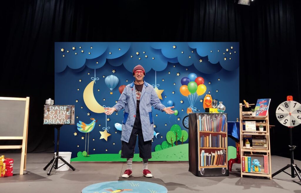 Un hombre sobre un escenario durante una obra infantil