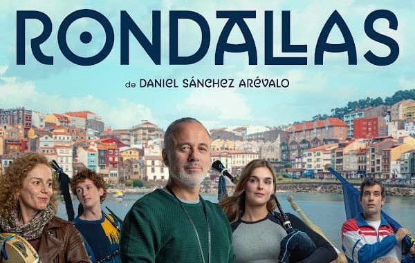 Cartel de la película Rondallas. Javier Gutiérrez posa frente a un pueblo pesquero