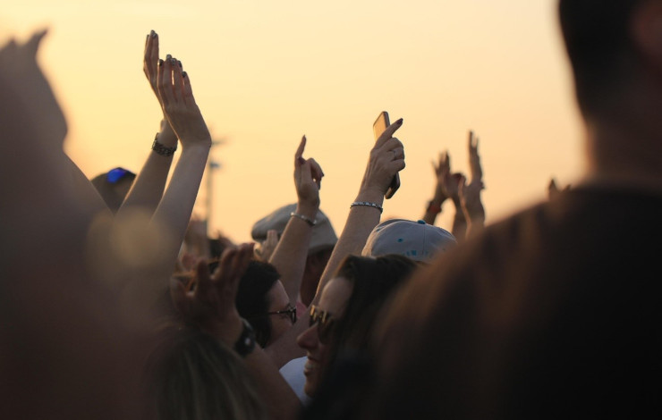 personas con las manos hacia arriba en un concierto