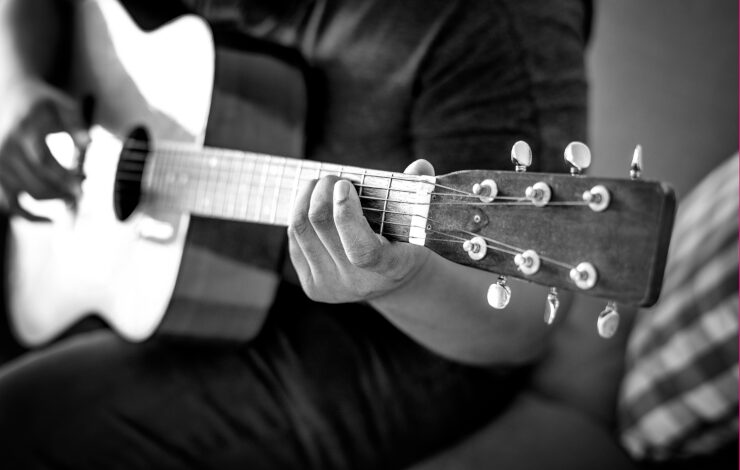 Foto en blanco y negro de un músico tocando la guitarra española