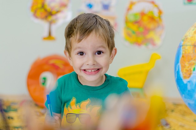 Niño sonriente sobre fondo con objetos infantiles