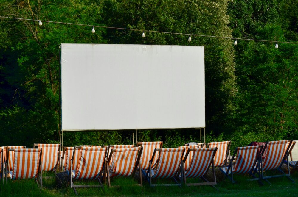 Pantalla de cine con hamacas de rayas rojas delante a modo de proyección