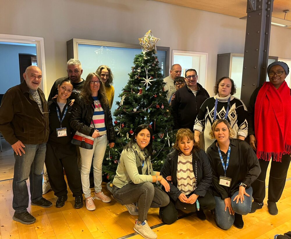 Participantes del programa de personas con discapacidad junto al árbol de navidad