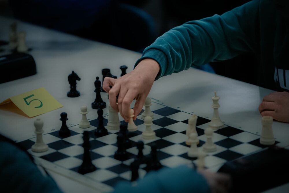 Mano moviendo un peón de ajedrez en el tablero