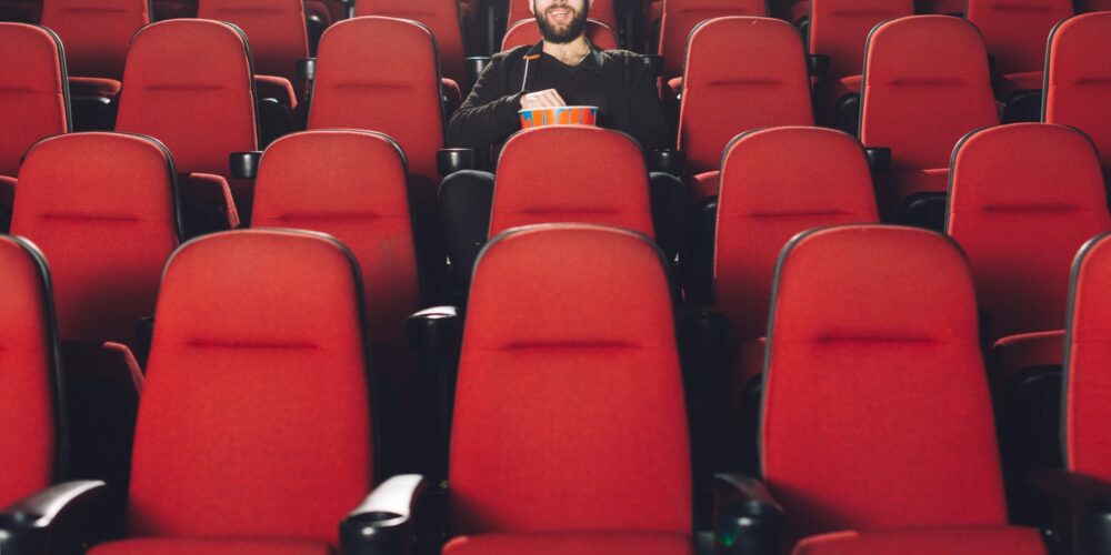Butacas de cine con chico comiendo palomitas