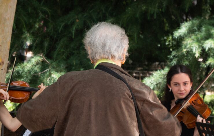 Imagen de una mujer de la tercera edad frente a dos músicas