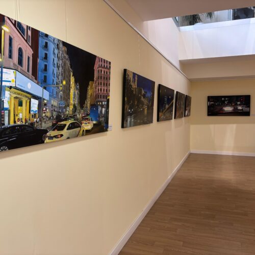 Cuadros de la exposición 'Naturalezas semimuertas y faros de Madrid' expuestos en la pared del centro cultural