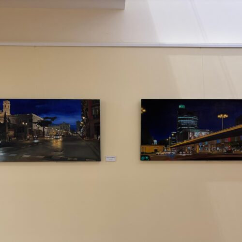 Cuadros de la exposición 'Naturalezas semimuertas y faros de Madrid' expuestos en la pared del centro cultural