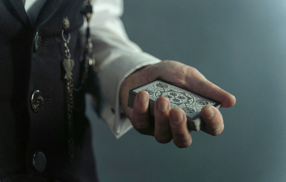 La mano de un mago con una baraja de cartas