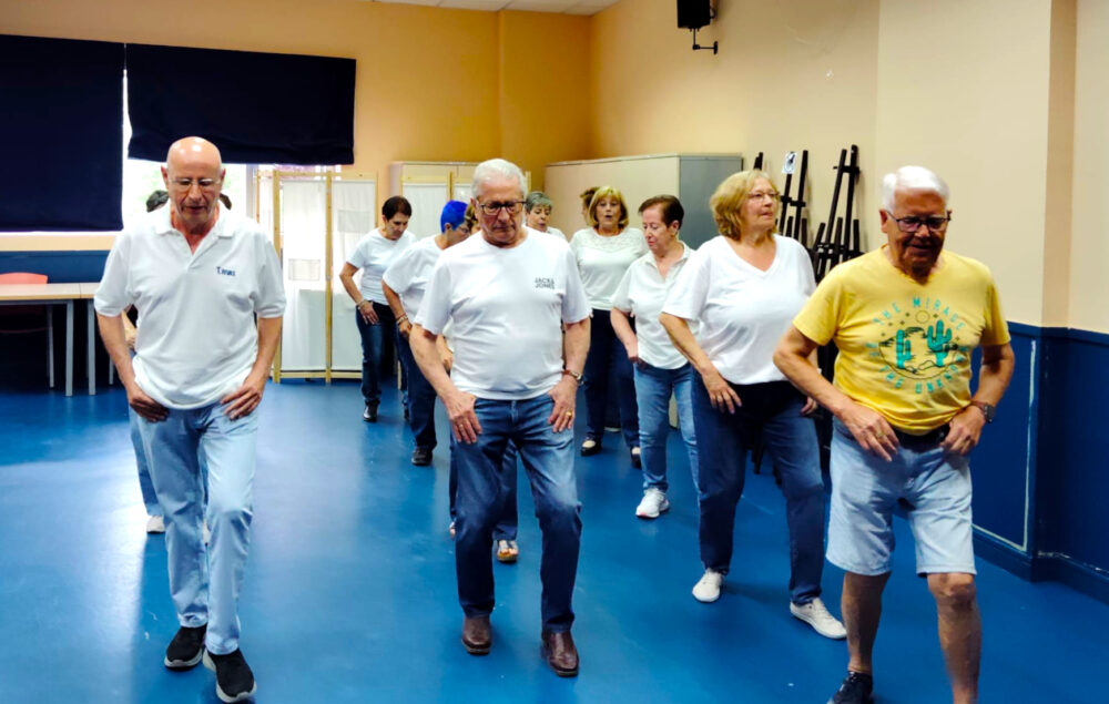 Grupo de personas de edad en vaqueros y camiseta bailando en línea