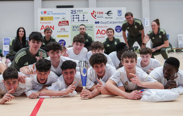 Foto de los jugadores del Real Madrid, ganadores del torneo en categoría masculina, aparecen con el trofeo mirando a cámara y tumbados en el suelo, con el photocall de fondo