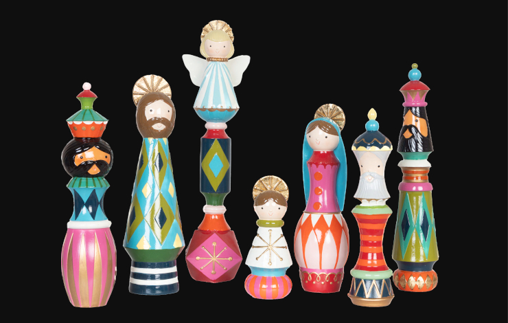 Foto de uno de los Nacimientos de la exposición 'La iconografía del belén alrededor del mundo' donde aparecen figuras coloridas de madera sobre fondo negro