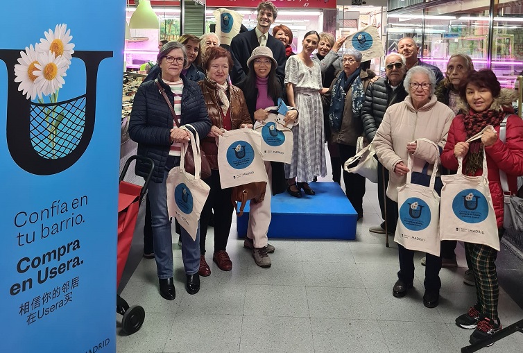 Personas y actores con la bolsa de la campaña Confía en Usera