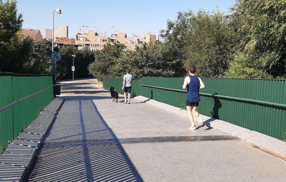 Dos corredores por la pasarela en Usera sobre el río Manzanares