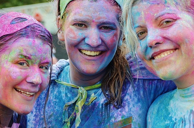 Tres chicas jóvenes cubiertas de pinturas de colores