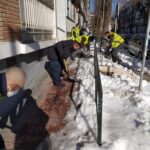 Despejando la nieve de acera y escaleras en la calle Villacarlos