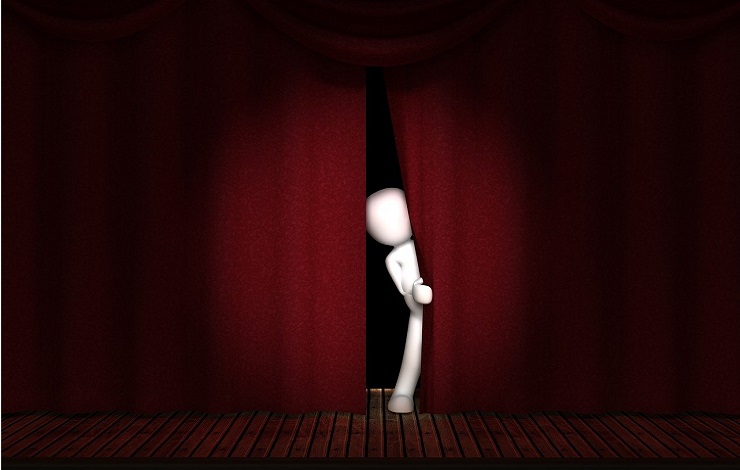 Ilustración de un muñeco articulado que se asoma por el telón de un escenario