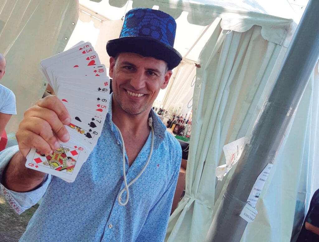 Un mago con un sombrero y una baraja de cartas