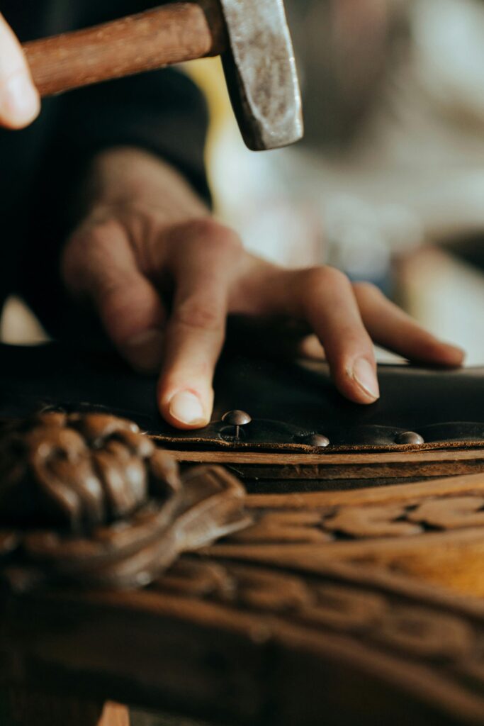 un hombre restaurando un mueble clásico con un martillo