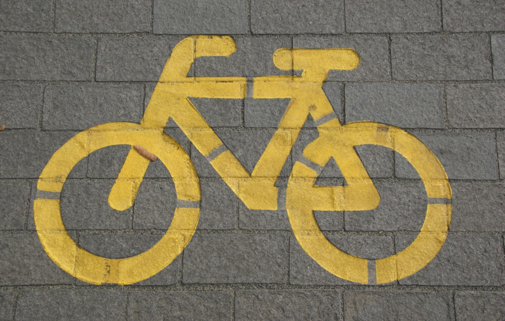 Ilustración de una bicicleta amarilla en el suelo dibujada señalando un carril bici