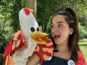 Una mujer con una marioneta de un pájaro blanco