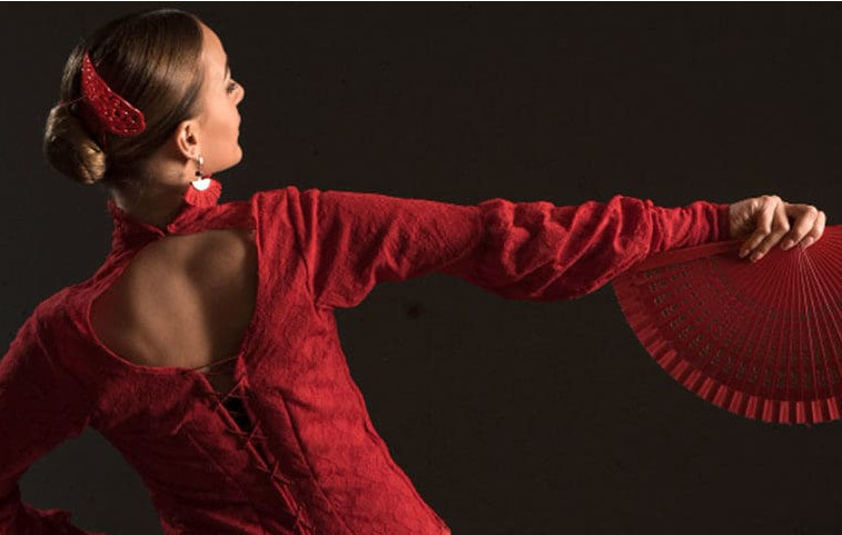 Una bailarina española con traje rojo y un abanico rojo